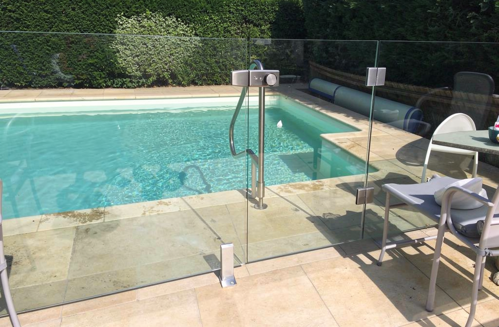 Barrière de piscine en verre trempé feuilleté installée au bord d'une piscine résidentielle