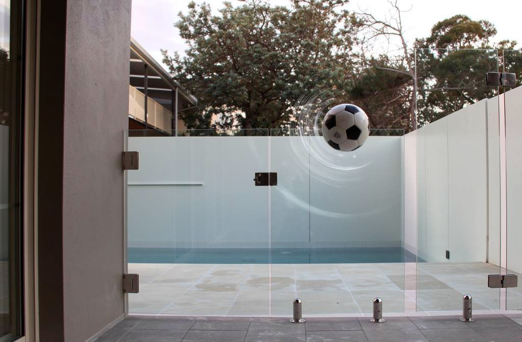 Barrière de piscine en verre trempé résistant aux chocs dans un jardin moderne