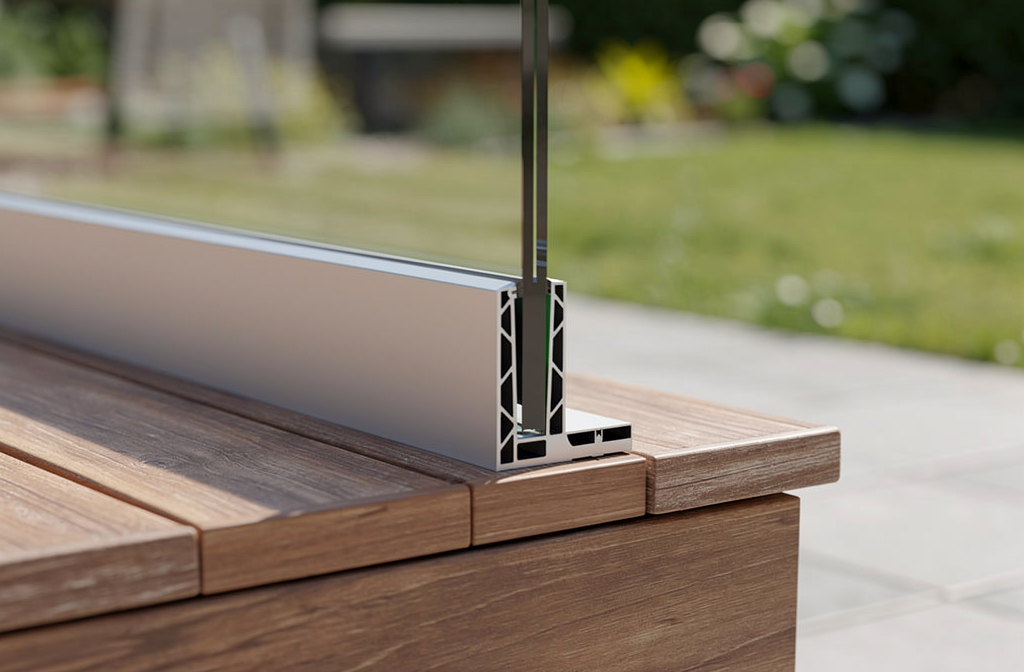 Profil de sol pour garde-corps en verre installé sur une terrasse en bois avec panneau de verre transparent.