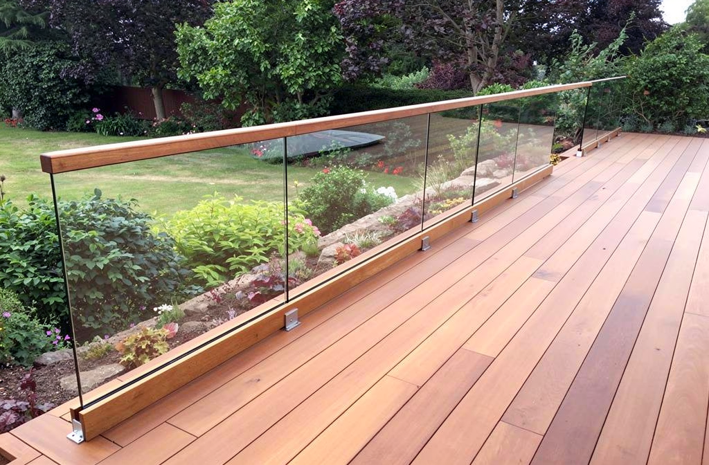 Garde-corps en verre avec fixation à la base sur terrasse extérieure en bois surplombant un jardin