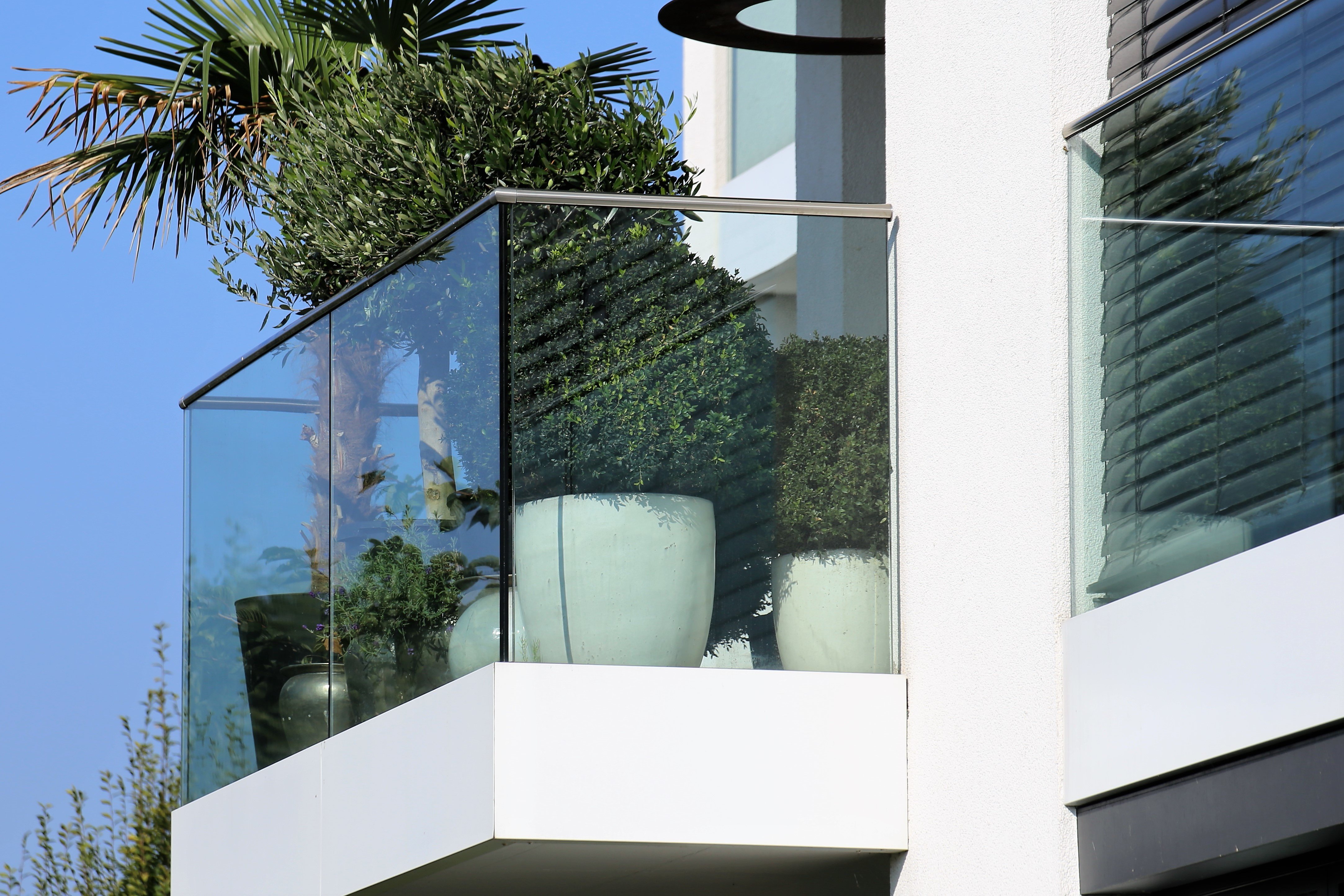 Garde-corps en verre feuilleté trempé sur balcon moderne, vue extérieure lumineuse.