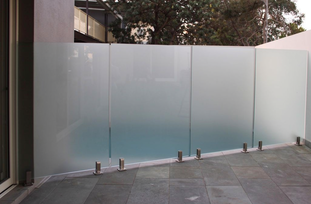 Verrière en verre dépoli sécurisant une terrasse moderne avec piscine